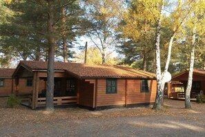 Ein rustikales Blockhaus mit Veranda, umgeben von Bäumen.