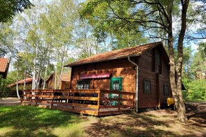 Eine Holzhütte mit Veranda, umgeben von Bäumen.