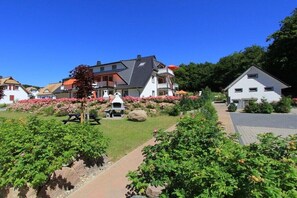 Ein Wohngebiet mit Häusern, einem gepflasterten Weg und einer Grillgelegenheit.