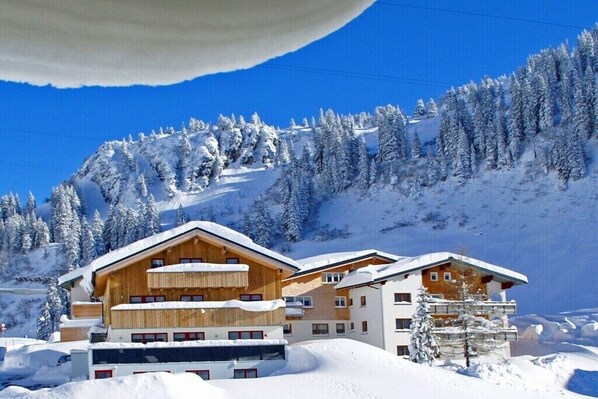 Ein schneebedecktes Bergresort mit Holzhäusern und Skipisten.