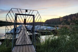 Eine Holzstele führt zu einem Hafen mit vertäuten Booten.