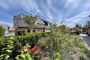 A residential house with a sloped roof, brick exterior, and a garden with red flowers. - 2 in Veronika's house (Wyk)