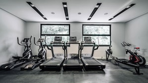 A gym with treadmills, elliptical machines, and a rowing machine. - Status M Apartments 98 (Becici)