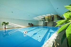 Ein Hallenbad mit einem Fußball, einer Treppe und einer Pflanze.