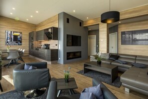 Ein modernes Wohnzimmer mit Kamin, Küche und Essbereich.