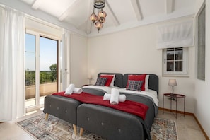 A double bed with red and white bedding, a small bedside table with a lamp, and a balcony with a view. - Villa BrickOliva (100551-K1) - Porec (Porec)