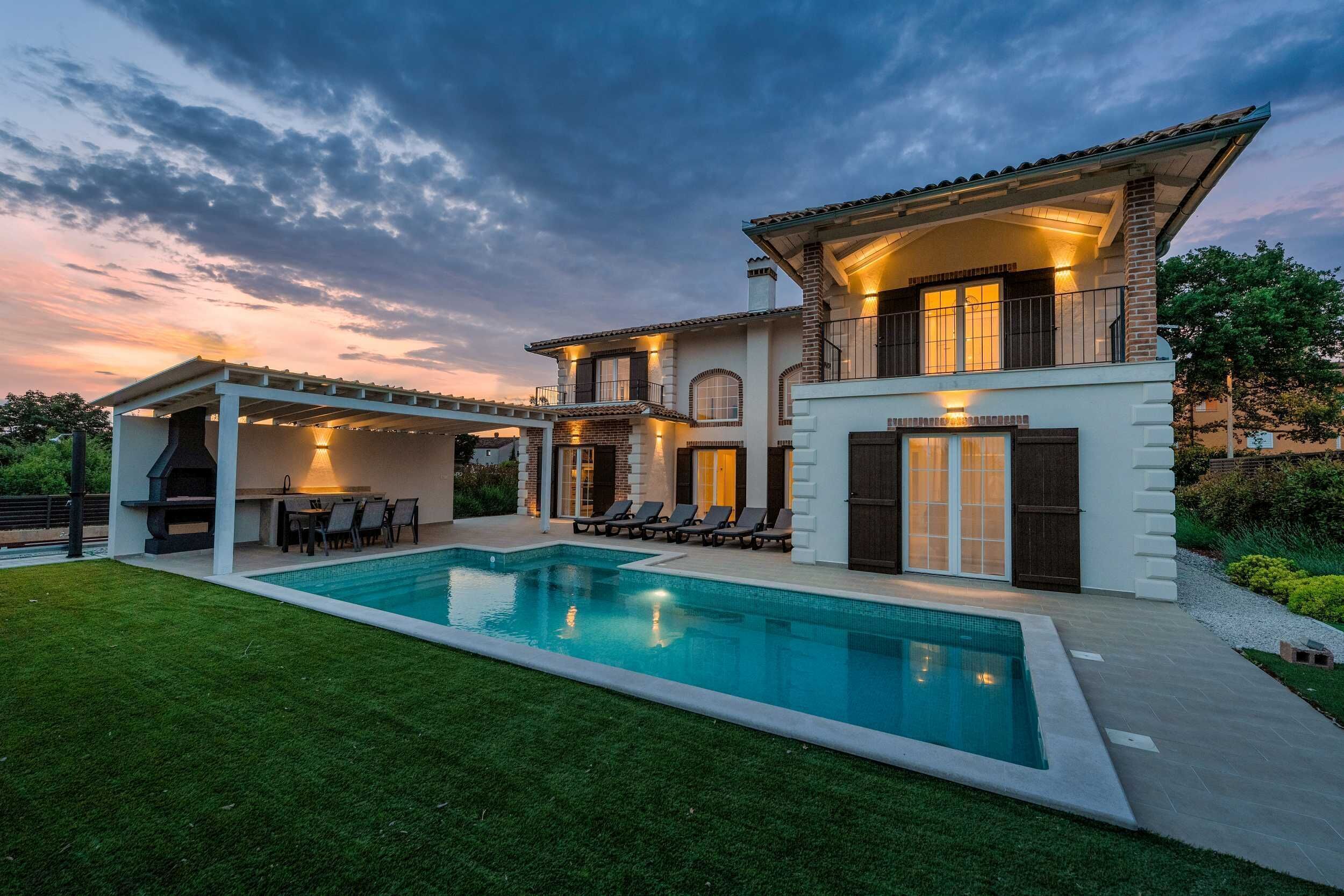 Une maison à deux étages avec une piscine, un espace salon extérieur et une pergola.