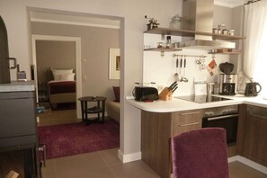 A compact kitchen with a dining area, a small table, and a bed in the adjacent room. - Holiday apartment in Neuhausen with sauna (Neuhausen)