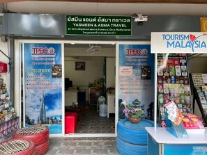 A travel agency with a signboard for Yasmeen & Asma Travel, a TBC logo, and a Tourism Malaysia sign. - Banhor Residence (AMPHOE MUEANG CHIANG MAI)