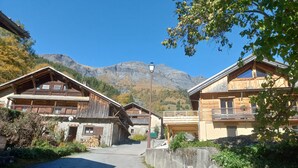 A mountain lodge with wooden architecture, a paved driveway, and a view of the mountains. - Charming, in a typical chalet and hamlet (Les Contamines-Montjoie)