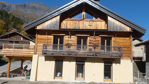 A wooden chalet with a balcony, large windows, and a mountain backdrop. - Charming, in a typical chalet and hamlet (Les Contamines-Montjoie)