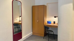 A small, neatly organized room with a desk, chair, a wardrobe, and a mirror. - NauKothi Jaipur (Jaipur)
