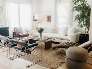 Ein modernes Wohnzimmer mit Sofa, Couchtisch und Sessel.