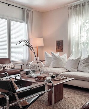 A modern living room with a sofa, coffee table, and a chair. - Caviar on Pine in Downtown McKinney • Sleeps 9 • Luxe Stay • Elevated Coffee Bar (McKinney)