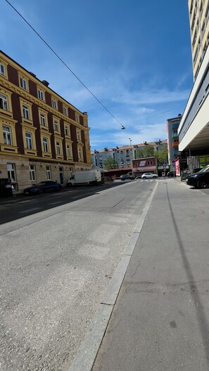 A street with buildings, a clear sky, and a parked white van.