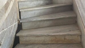 A marble staircase with a handrail, leading to a landing with a patterned wall. - Ritza Hotel (Tunis)