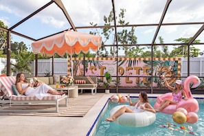 An outdoor pool area with lounge chairs, a covered seating area, and a decorative mural. - Palm Royale Pool Oasis •10m DT St Pete •15m Beach (St. Petersburg)