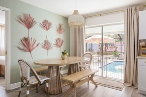 A dining area with a round table, chairs, and a hanging light fixture. - Palm Royale Pool Oasis •10m DT St Pete •15m Beach (St. Petersburg)