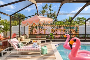 A poolside area with a covered seating area, a mural, and a flamingo float. - Palm Royale Pool Oasis •10m DT St Pete •15m Beach (St. Petersburg)