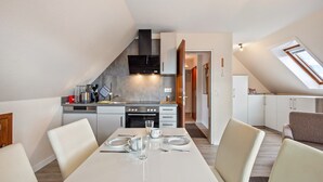 Een moderne keuken met een eethoek, een inbouwoven en een magnetron.