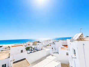 Ein Küstenwohngebiet mit weißen Gebäuden, blauem Himmel und einem Strand im Hintergrund.