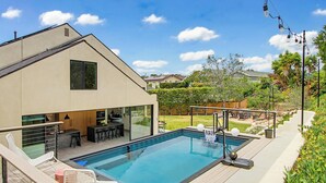 A modern house with a swimming pool, outdoor seating, and a well-maintained garden. - Modern Encinitas Retreat (Encinitas)