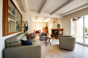 Amplia sala de estar con sofá, sillón y chimenea.