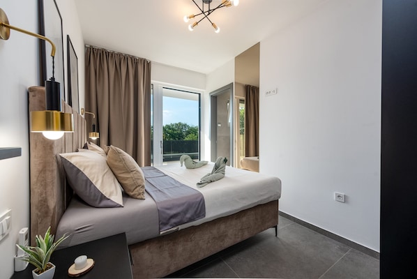 A modern bedroom with a large bed, a bedside table with a plant, and a view of the outdoors. - Villa Salt2 Zadarvillas (Nin)