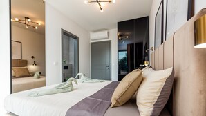 Ein modernes Schlafzimmer mit einem großen Bett, Nachttischen, einem Kleiderschrank und einer Klimaanlage.