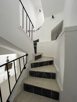 A staircase with black railings and white walls, leading to a landing with a small shelf. - Charming 19th-century House With Sea Views in Tangier (Tangier)