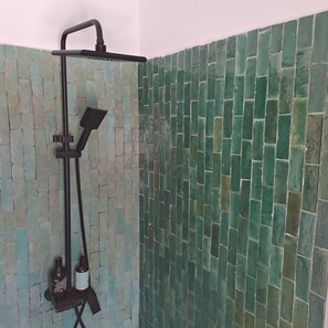 A shower with a black hose and a handheld showerhead mounted on a wall with green mosaic tiles. - Charming 19th-century House With Sea Views in Tangier (Tangier)