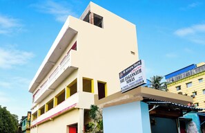 Un edificio de varios pisos con un letrero que anuncia habitaciones en alquiler.
