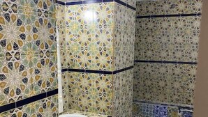 A bathroom with patterned tiles, a sink, and a shower area. - Hôtel Russie (Tunis)