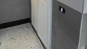 A room with a white door, a window with a decorative grille, and a tiled floor. - Hôtel Russie (Tunis)