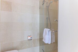 A shower with a glass door, a towel rack, and a soap dispenser. - Les Bougainvilliers Studios in Batroun (Batroun)