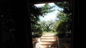 Une vue à travers une porte donnant sur un espace intérieur carrelé, avec un escalier menant à l’extérieur.