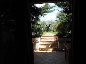 A view through a doorway to a tiled indoor area with a staircase leading outside. - Lovely apartment with garden in the Gulf of Orosei 5 minutes from the sea (Orosei)
