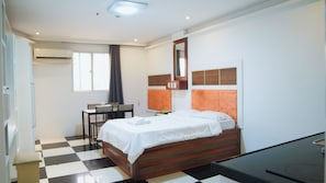 Un dormitorio moderno con una cama, un escritorio y una silla.
