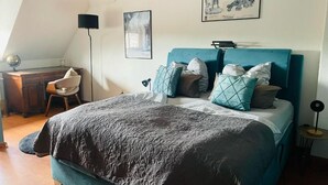 Ein Schlafzimmer mit einem Bett, einem Schreibtisch, einem Stuhl und einer Lampe.
