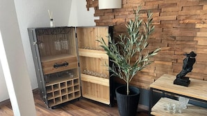 Eine Ecke mit einem Holzkabinett mit mehreren Regalen, einer Topfpflanze und einem kleinen Tisch mit einer Skulptur.