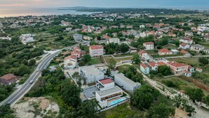 Vista aérea de una zona residencial con casas, calles y una masa de agua al fondo.