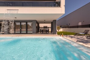 A modern pool with a water feature, outdoor seating, and a minimalist architectural design. - Villa Salt2 Zadarvillas (Nin)