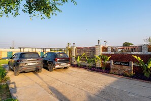 Ein Parkplatz mit zwei SUVs, einer Backsteinmauer und einem Schild mit der Aufschrift 'CLASSIC Retreat'.