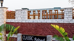A brick wall with a sign that reads 'CLASSIC Retreat.' - Alaya Stays Batlaw Classic 5 BHK Villa with Pvt Pool & Gazebo (Gurugram)