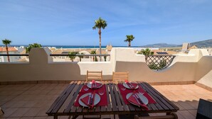 Una terrazza con un tavolo apparecchiato per due, con vista sulla costa.