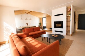 Ein modernes Wohnzimmer mit einer Couch, einem Couchtisch und einem Kamin.