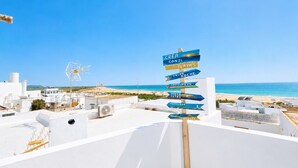 A rooftop with a signpost indicating directions to various locations. - CREA Conil Apartments II (Conil de la Frontera)