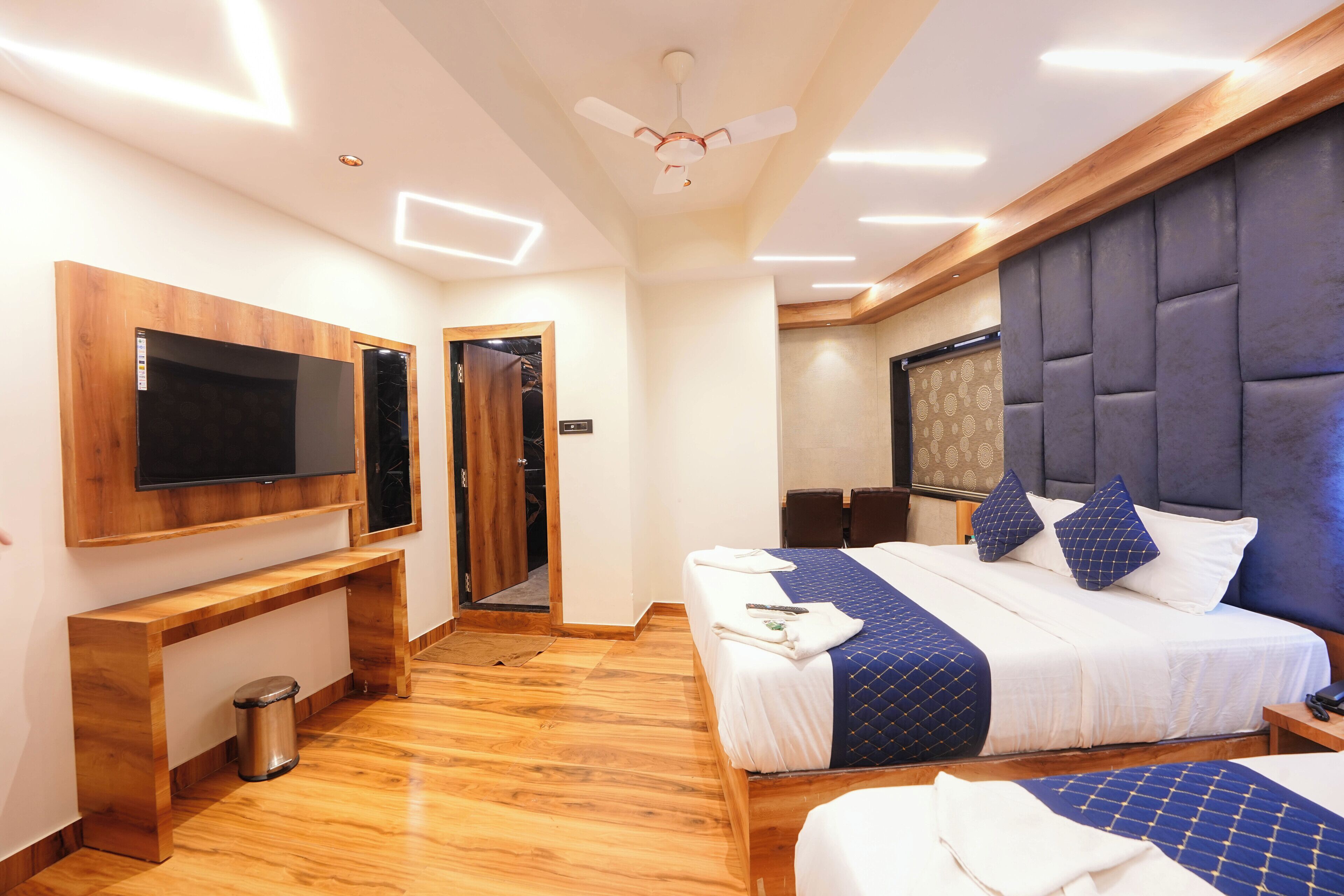 A hotel room with a bed, a TV, a desk, and a wardrobe.