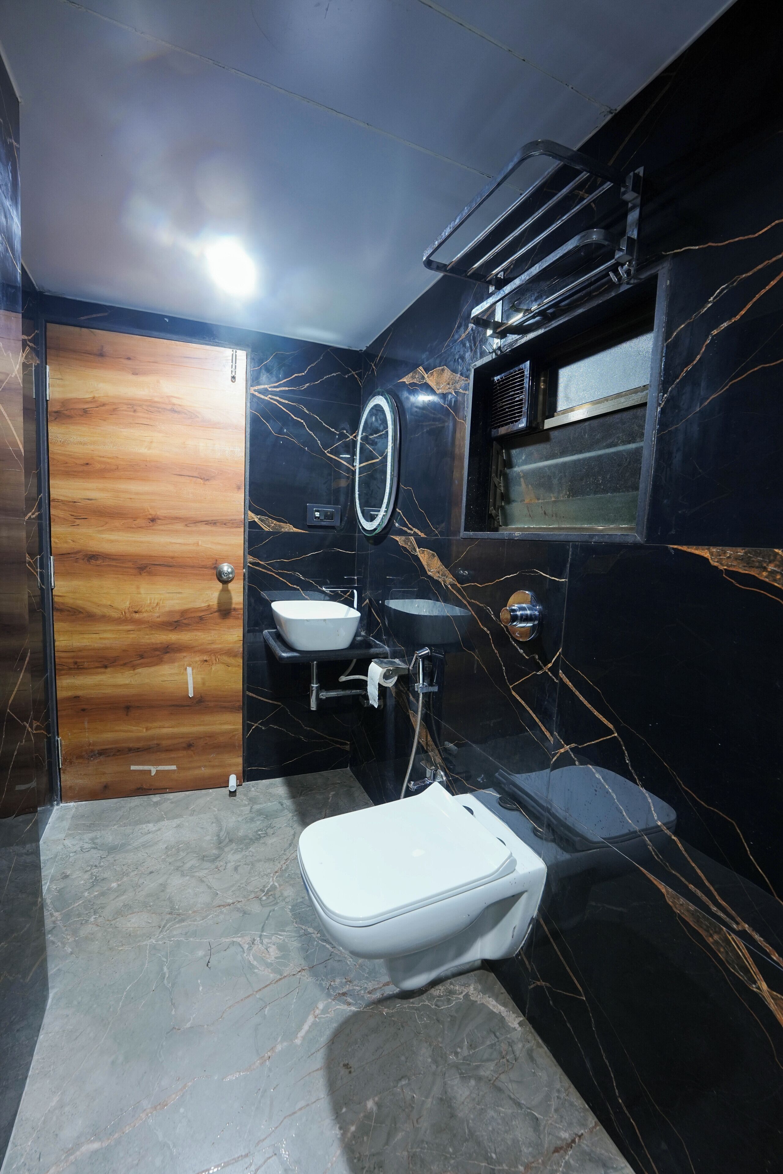 A bathroom with a white toilet, a sink, and a mirror.