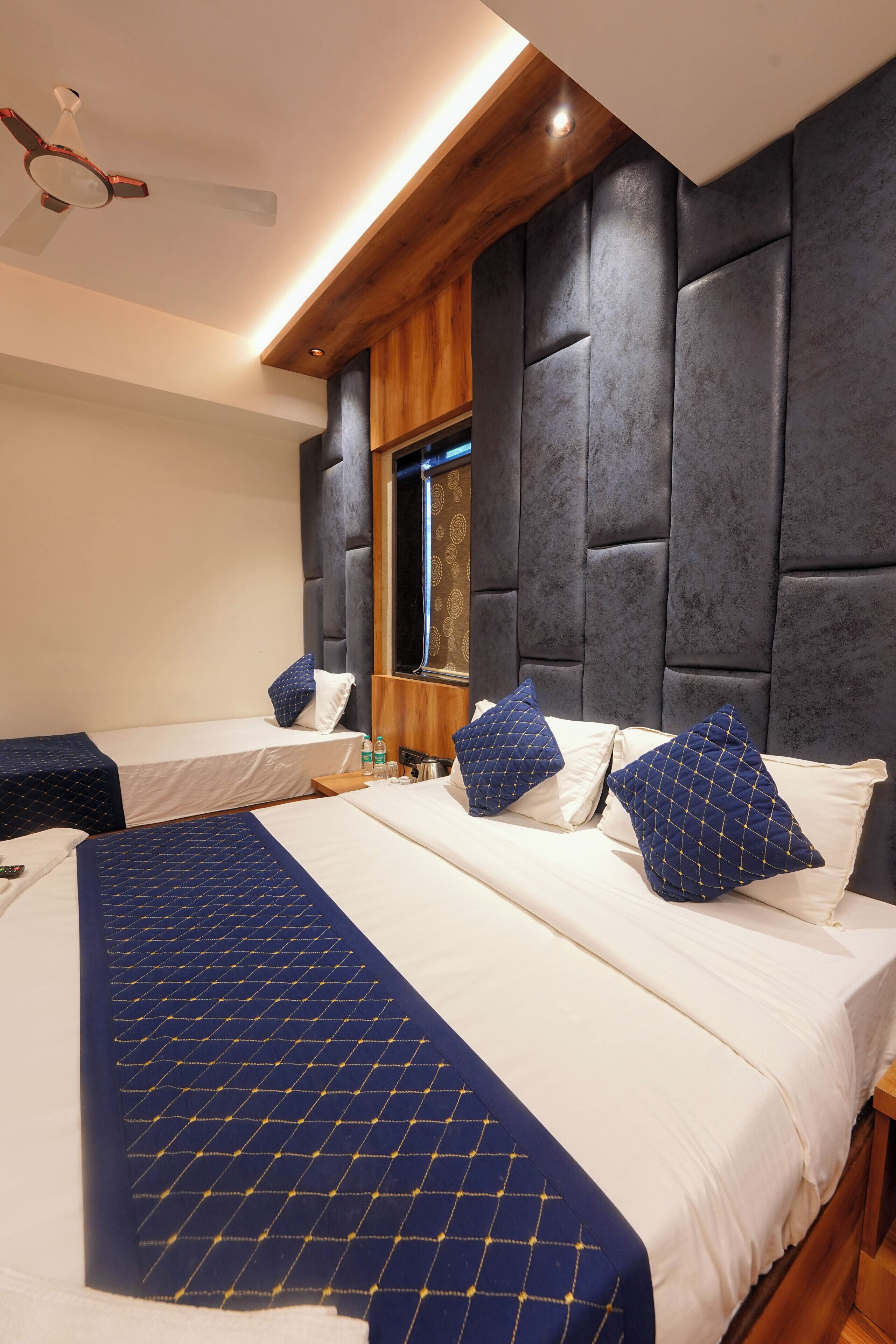Ein Hotelzimmer mit zwei Betten, einer Holzbalkendecke, einem großen Spiegel und modernem Design.